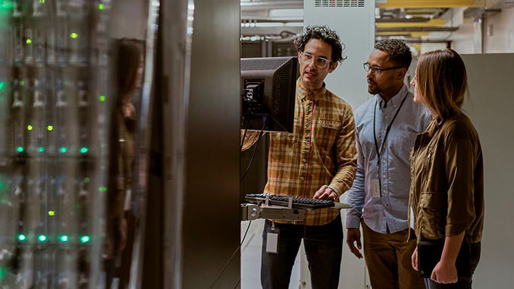 Technicians using computer in server room
