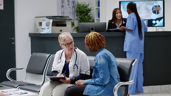 Doctor talking with a patient in a clinic waiting area