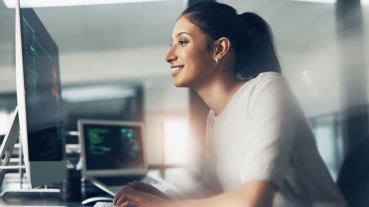 A woman smiling while working at a computer