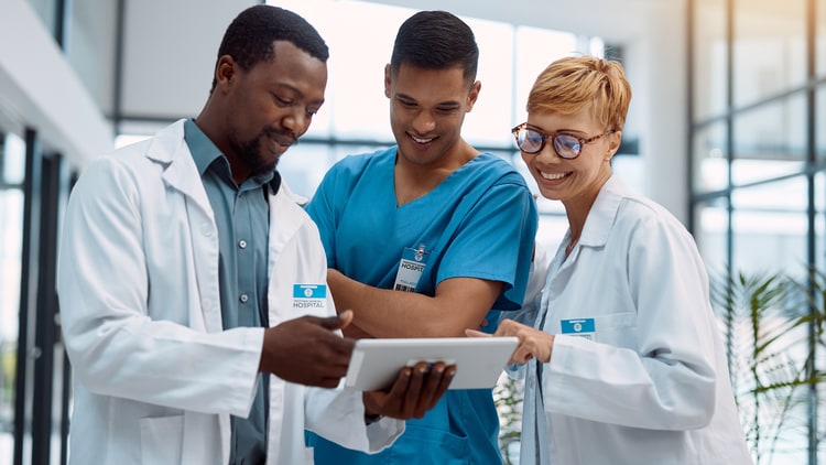 group of healthcare workers looking at a tablet