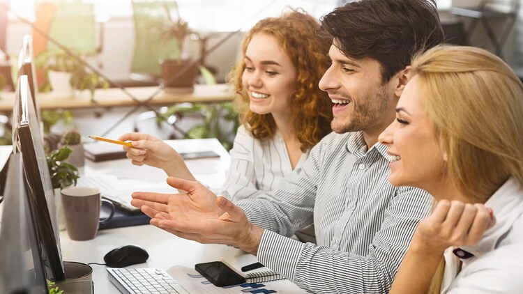 Young team looking at computer screen in office together