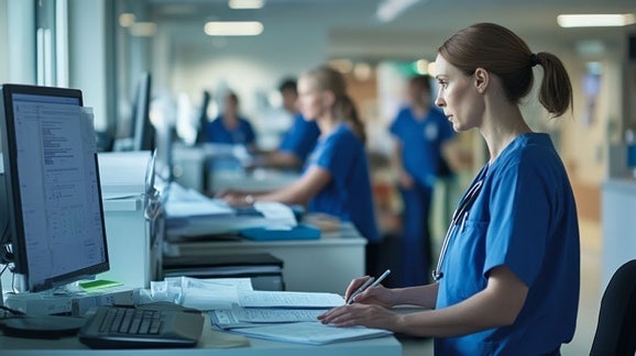 Healthcare worker standing while working on a computer