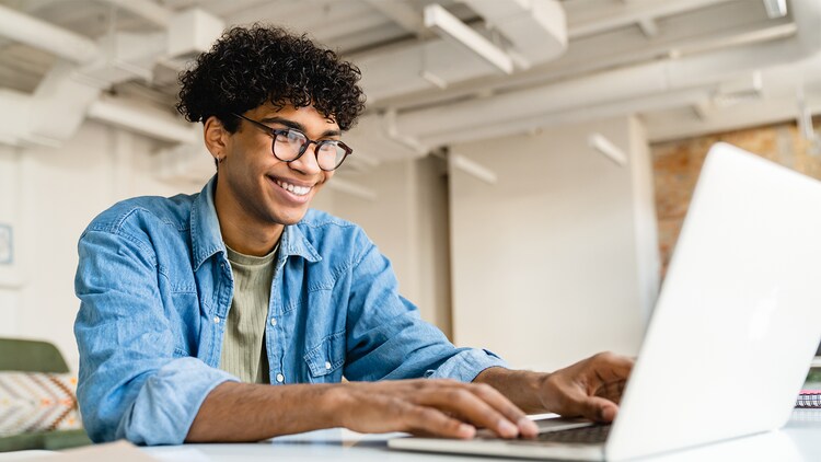 Man smiling at his open laptop