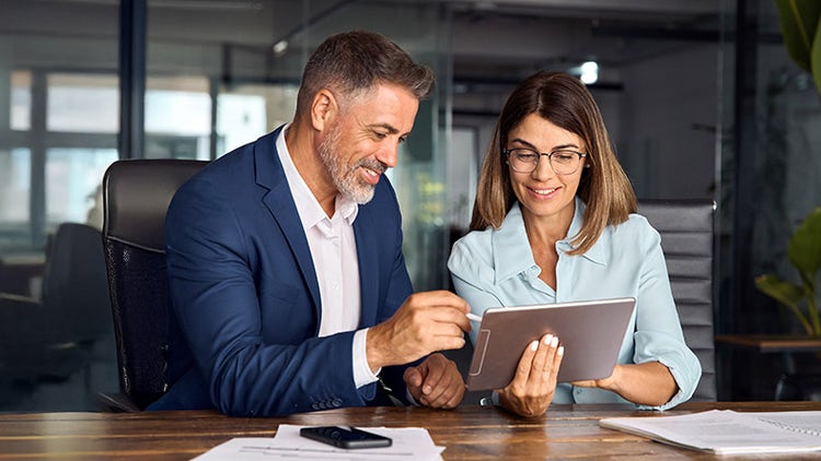 Two colleagues working together on tablet in the office