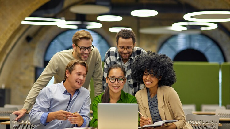 Five colleagues gathered around a laptop
